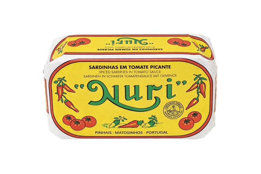 A tin of Nuri Spiced Sardines in Tomato Sauce, featuring a bright yellow label with green 'Nuri' lettering and illustrations of red tomatoes and chili peppers, shown on a transparent checkerboard background.